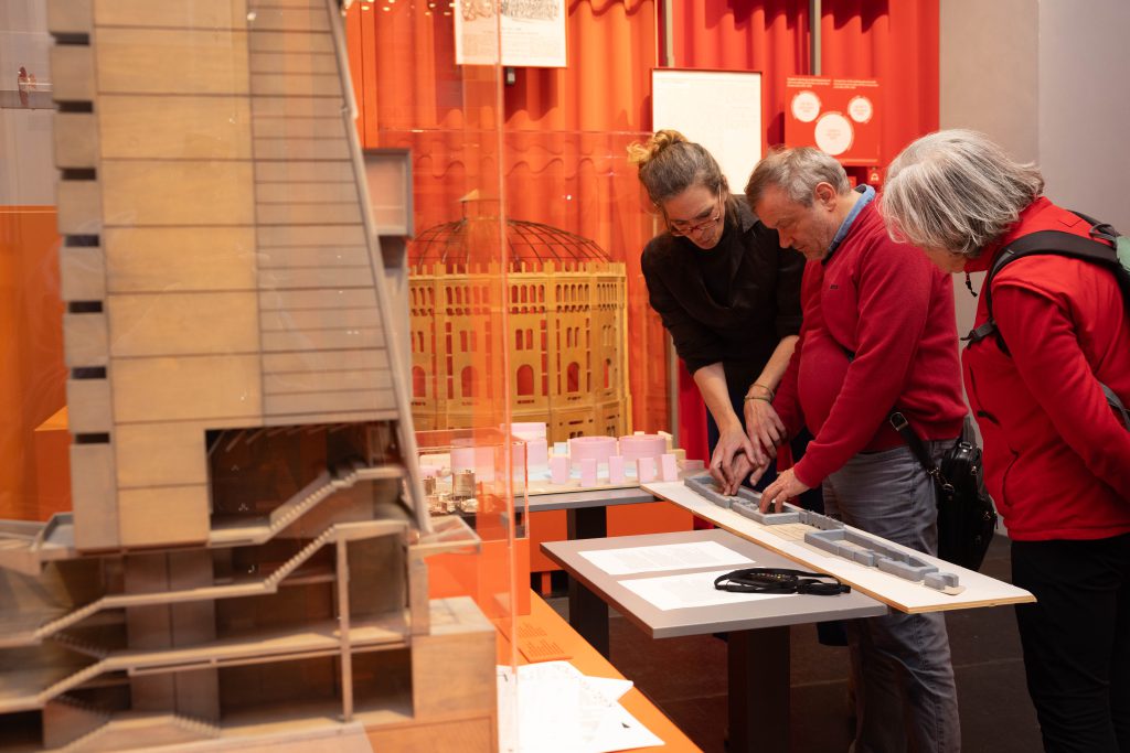 3 Personen in einer Ausstellung, 2 davon tasten ein Model ab