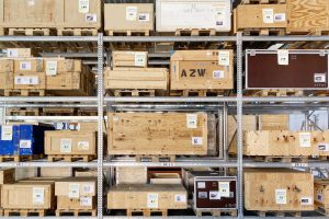 Many wooden crates on a metal shelf, one labelled AZW