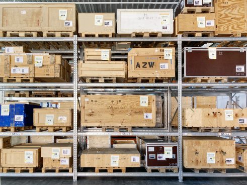 Many wooden crates on a metal shelf, one labelled AZW