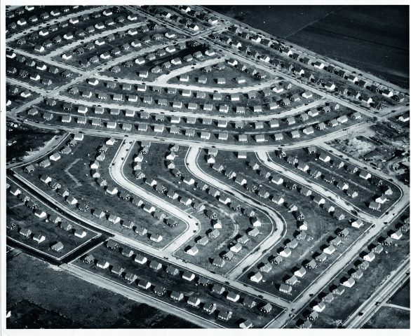 b/w photo from a bird's eye view of a housing estate with many houses of the same size