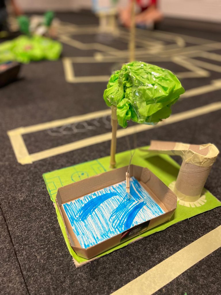 aus Karton gefertigte Landschaft mit Baum, Pool und Rutsche