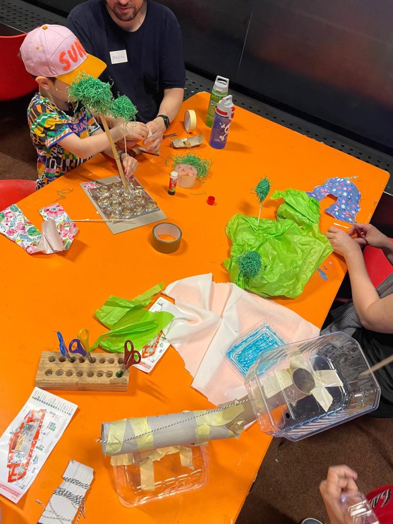 orange table where children can make things with paper, scissors and adhesive tape